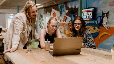 Drie vrouwen achter laptop - Foto: Henrieke Besselink Fotografie