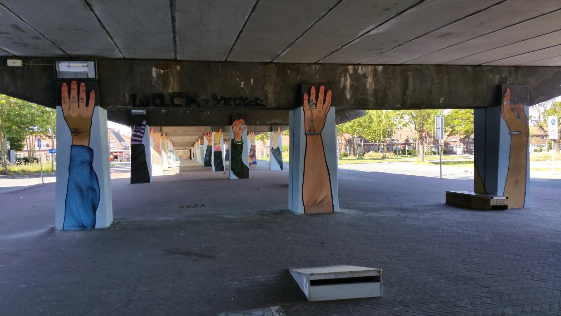 Pijlers van brug beschilderd met armen die de brug dragen