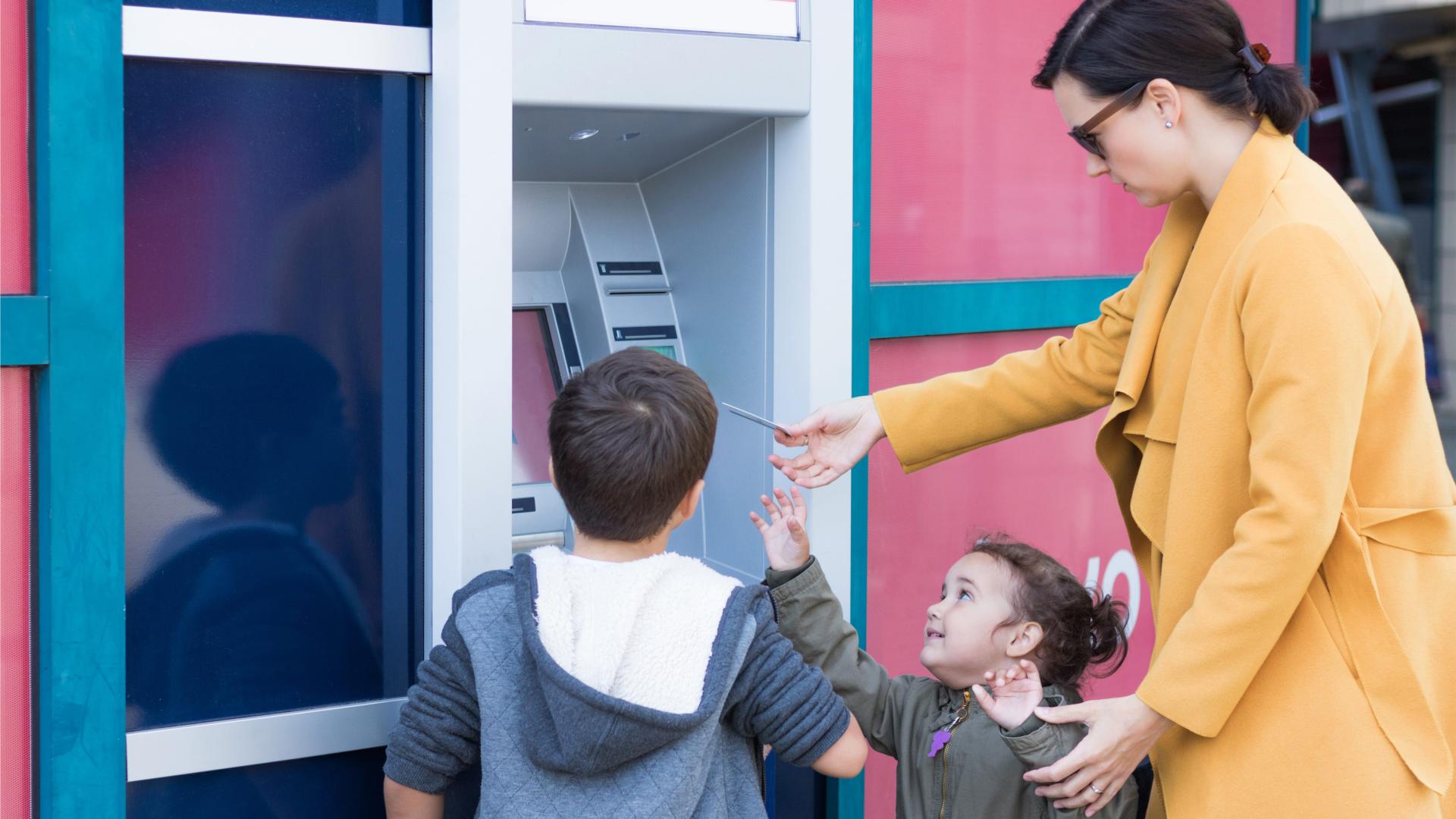 Vrouw met 2 kinderen bij geldautomaat